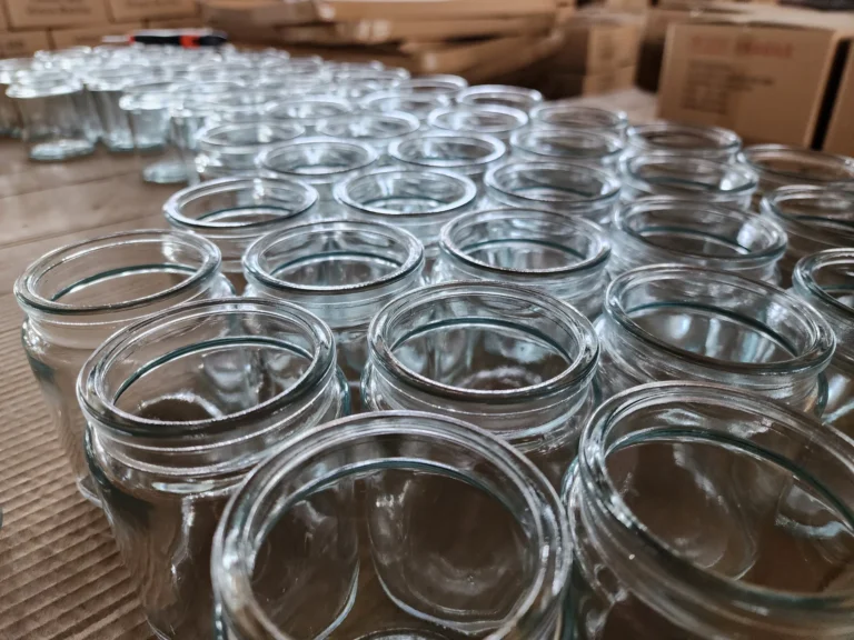 Clear glass candle vessels arranged in a workshop