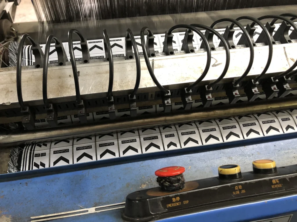 Detail of woven label production on a machine